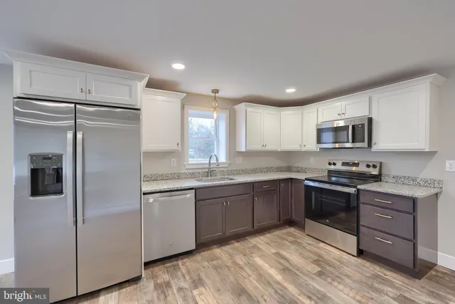 a kitchen with stainless steel appliances granite countertop a refrigerator and a stove top oven