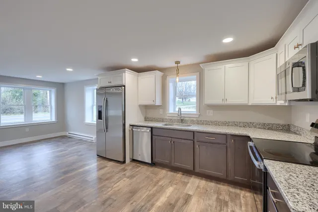 a kitchen with stainless steel appliances granite countertop a refrigerator sink and cabinets