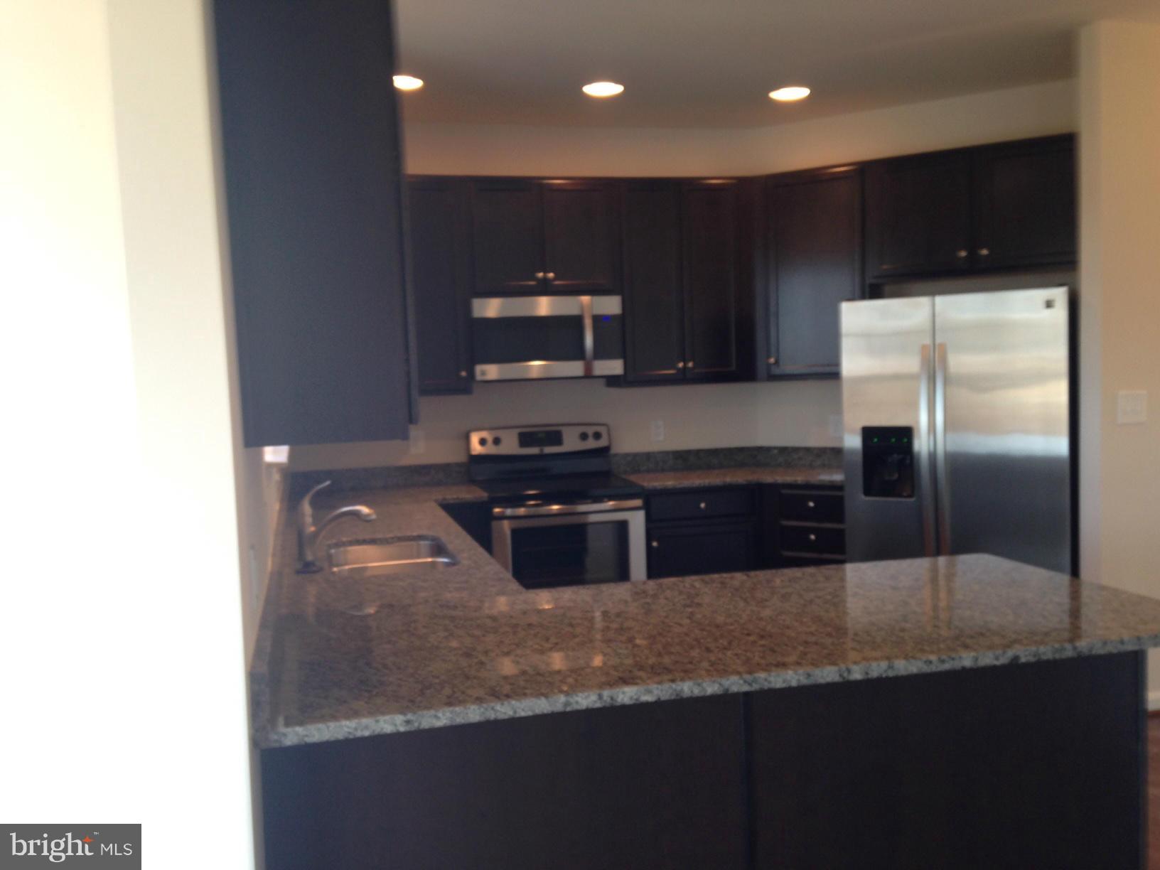 5279 Longbow Road King George, VA 22485 - Photo 30 of 30 a kitchen with stainless steel appliances granite countertop a sink and a refrigerator
