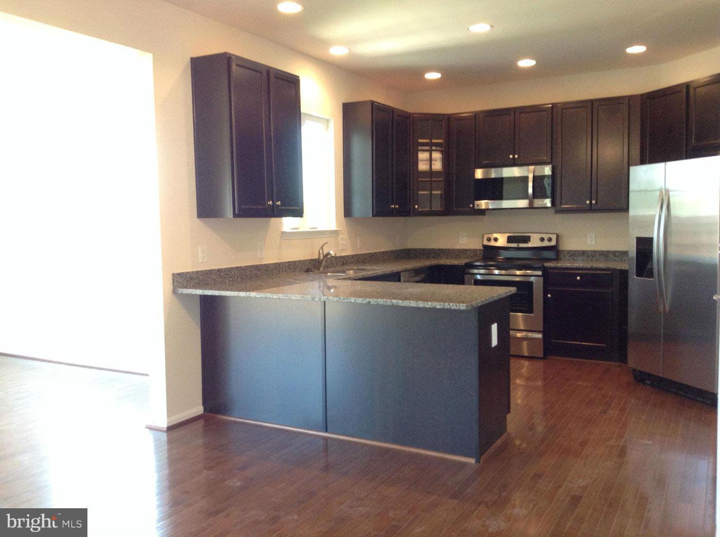 5279 Longbow Road King George, VA 22485 - Photo 5 of 30 a kitchen with stainless steel appliances granite countertop wooden cabinets a refrigerator a sink a stove a microwave and wooden floors