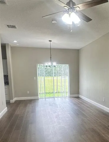 an empty room with fan and windows