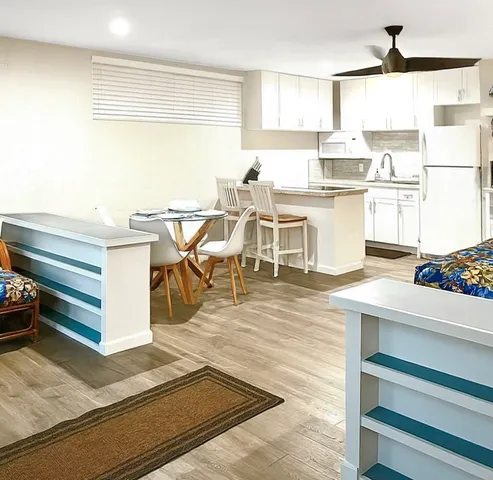 a room with stainless steel appliances kitchen island granite countertop a stove and a refrigerator