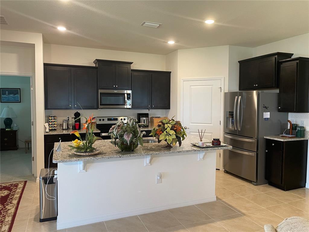 6209 Southwest 89th St Road Ocala, FL 34476 - Photo 12 of 27 a view of a kitchen with refrigerator and a stove top oven