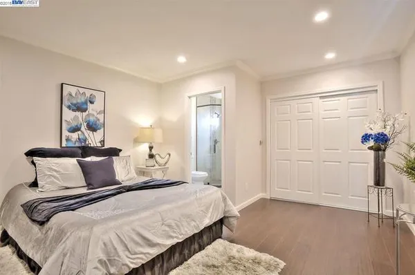 a bedroom with a bed and a painting on the wall