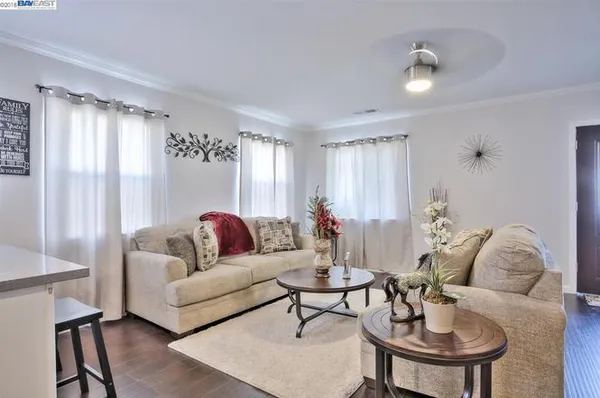 a living room with furniture kitchen and a chandelier