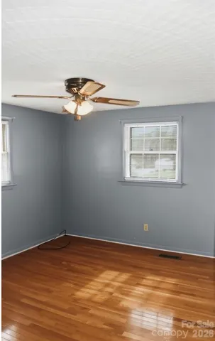 a view of a room with wooden floor and a window