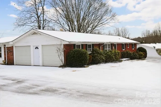 a front view of a house with a yard covered in snow