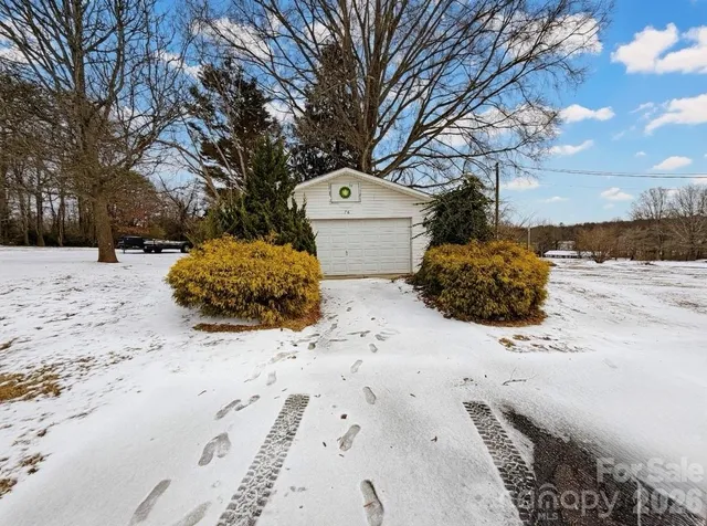 a front view of a house with a yard covered with snow