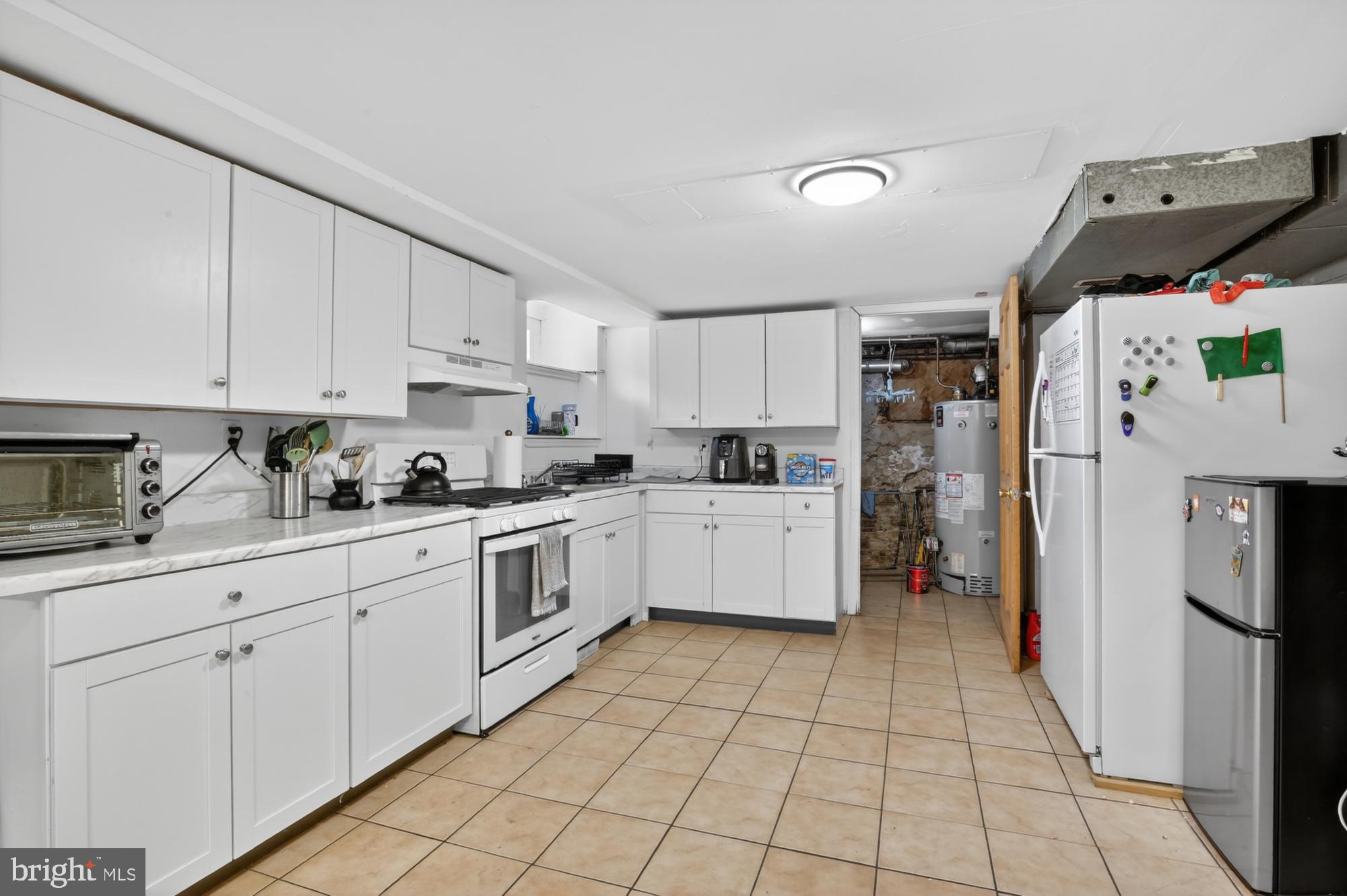 4001 Baltimore Avenue Philadelphia, PA 19104 - Photo 12 of 40 a kitchen with a refrigerator a sink and cabinets