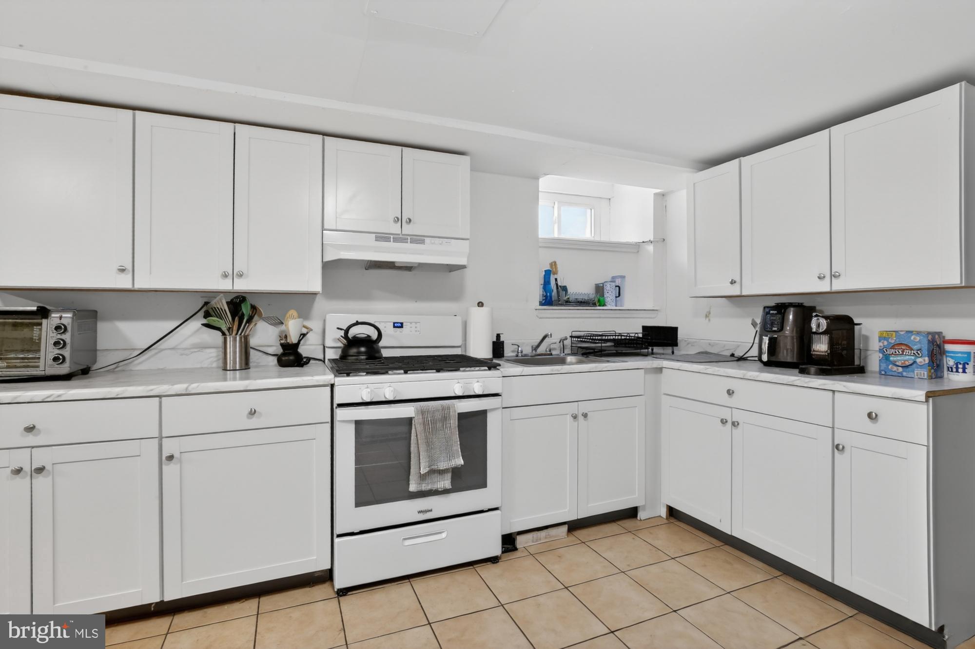 4001 Baltimore Avenue Philadelphia, PA 19104 - Photo 13 of 40 a kitchen with white cabinets stainless steel appliances and sink