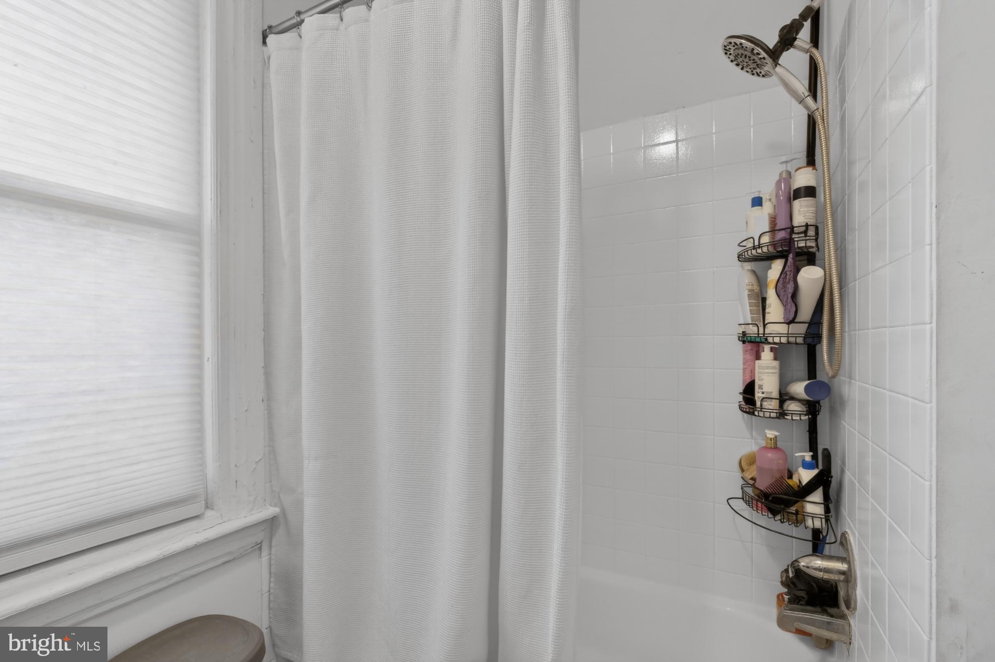 4001 Baltimore Avenue Philadelphia, PA 19104 - Photo 28 of 40 a bathroom with a shower curtain and a window