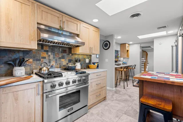 a kitchen with stainless steel appliances granite countertop a stove a sink and a refrigerator