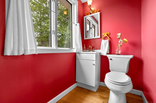 a bathroom with a toilet a sink and a window