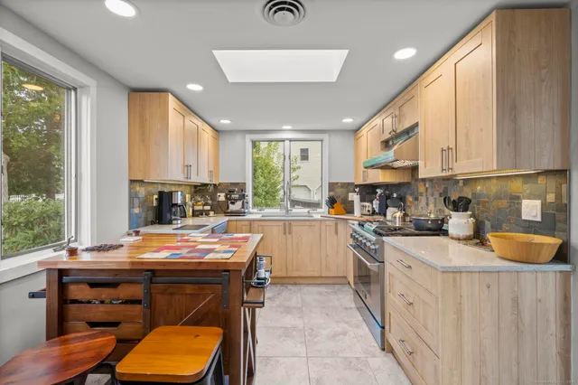 a kitchen with stainless steel appliances a stove a sink a refrigerator and cabinets