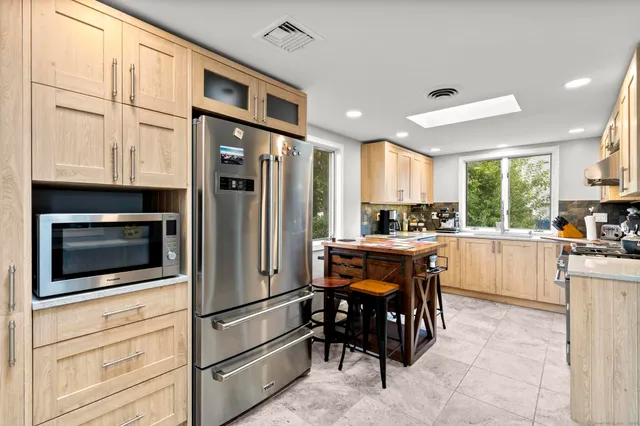 a kitchen with stainless steel appliances granite countertop a refrigerator and microwave