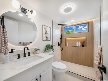 a bathroom with a sink mirror vanity and toilet