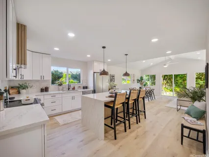 a kitchen with a dining table chairs and white appliances