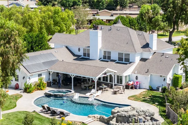 an aerial view of a house with swimming pool and chairs