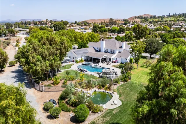 an aerial view of residential houses with outdoor space and trees