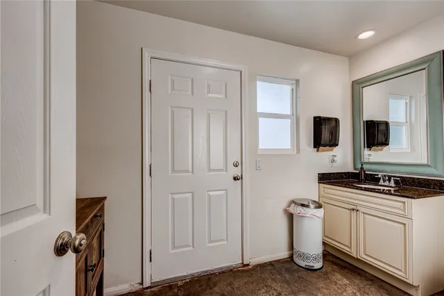 a kitchen with white cabinets and sink