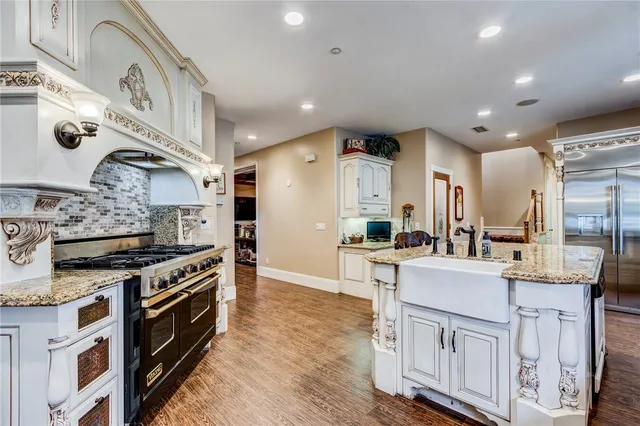 a kitchen with stainless steel appliances granite countertop a stove and a sink