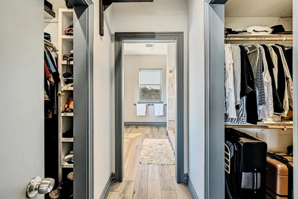 a view of walk in closet with clothes and shoes