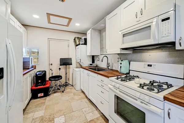 a kitchen with stainless steel appliances a stove a white cabinets and a refrigerator