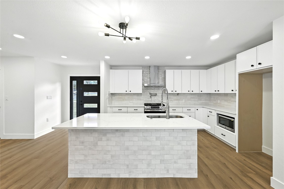 815 Buckingham Place Austin, TX 78745 - Photo 12 of 33 a living room with stainless steel appliances kitchen island granite countertop a refrigerator a stove a sink and white cabinets with wooden floor