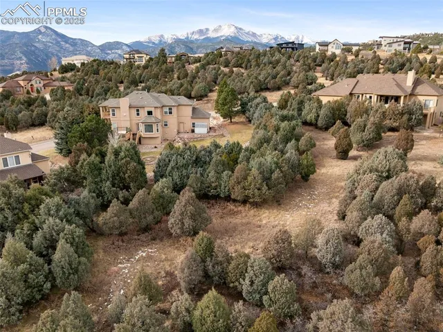 an aerial view of a house with a mountain in the background