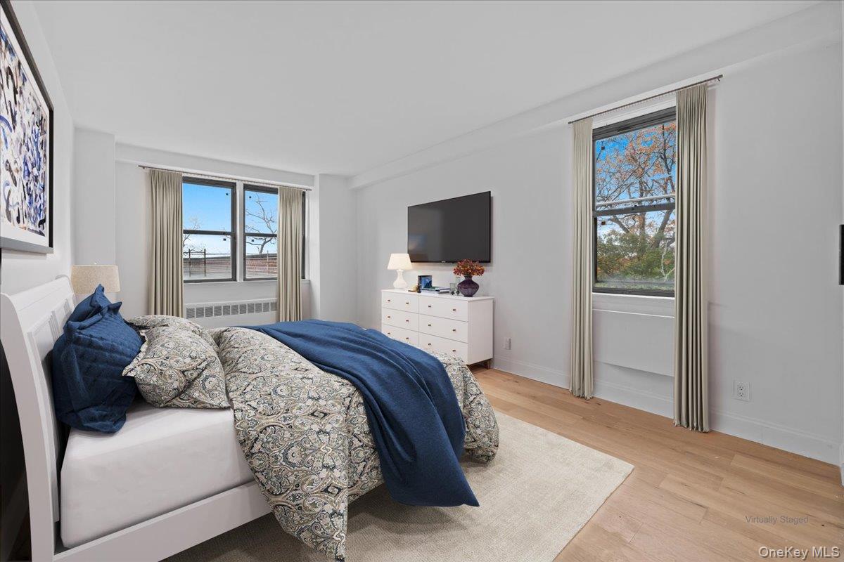 5700 Arlington Avenue, Unit 1C Bronx, NY 10471 - Photo 11 of 18 a bedroom with a large bed and a flat tv screen on a dresser