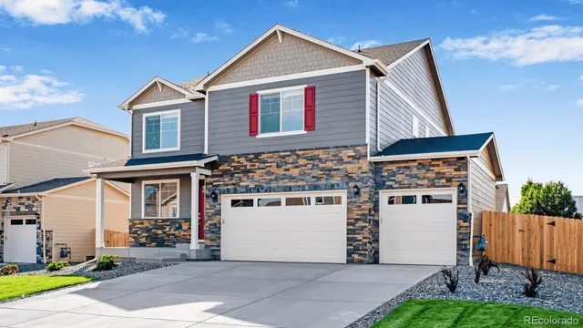 a view of white house with a small yard and large tree