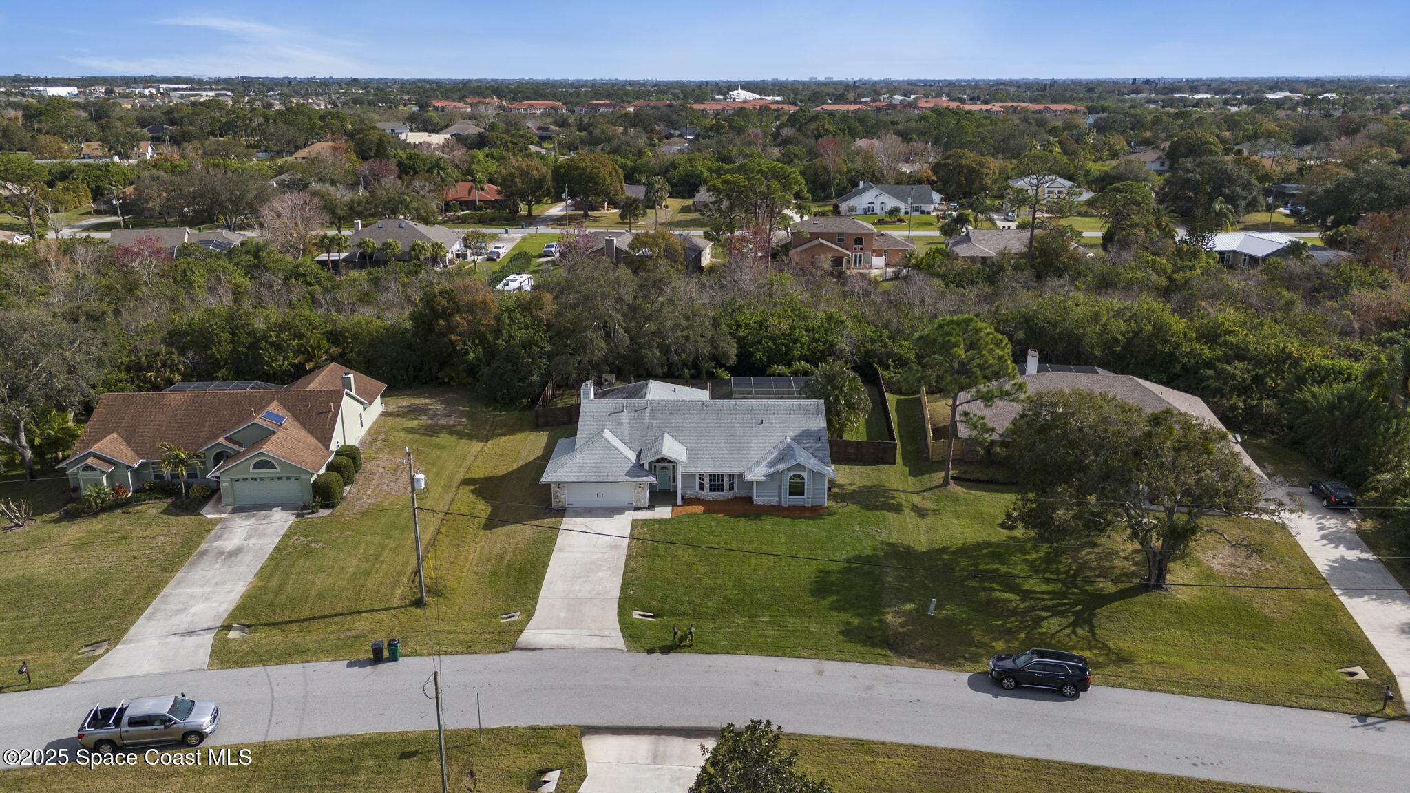 an aerial view of residential houses with outdoor space and parking