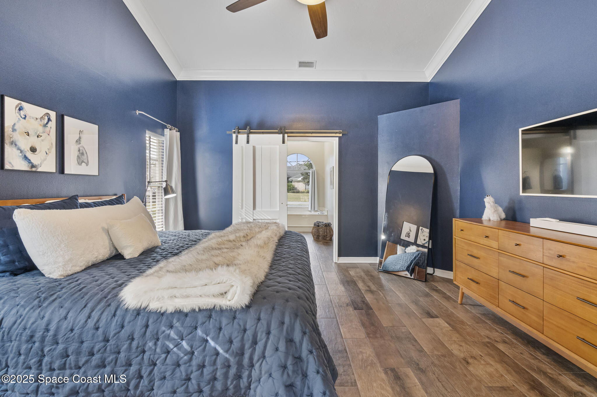 4089 Mallard Drive Melbourne, FL 32934 - Photo 13 of 53 a bedroom with a large bed and wooden floor