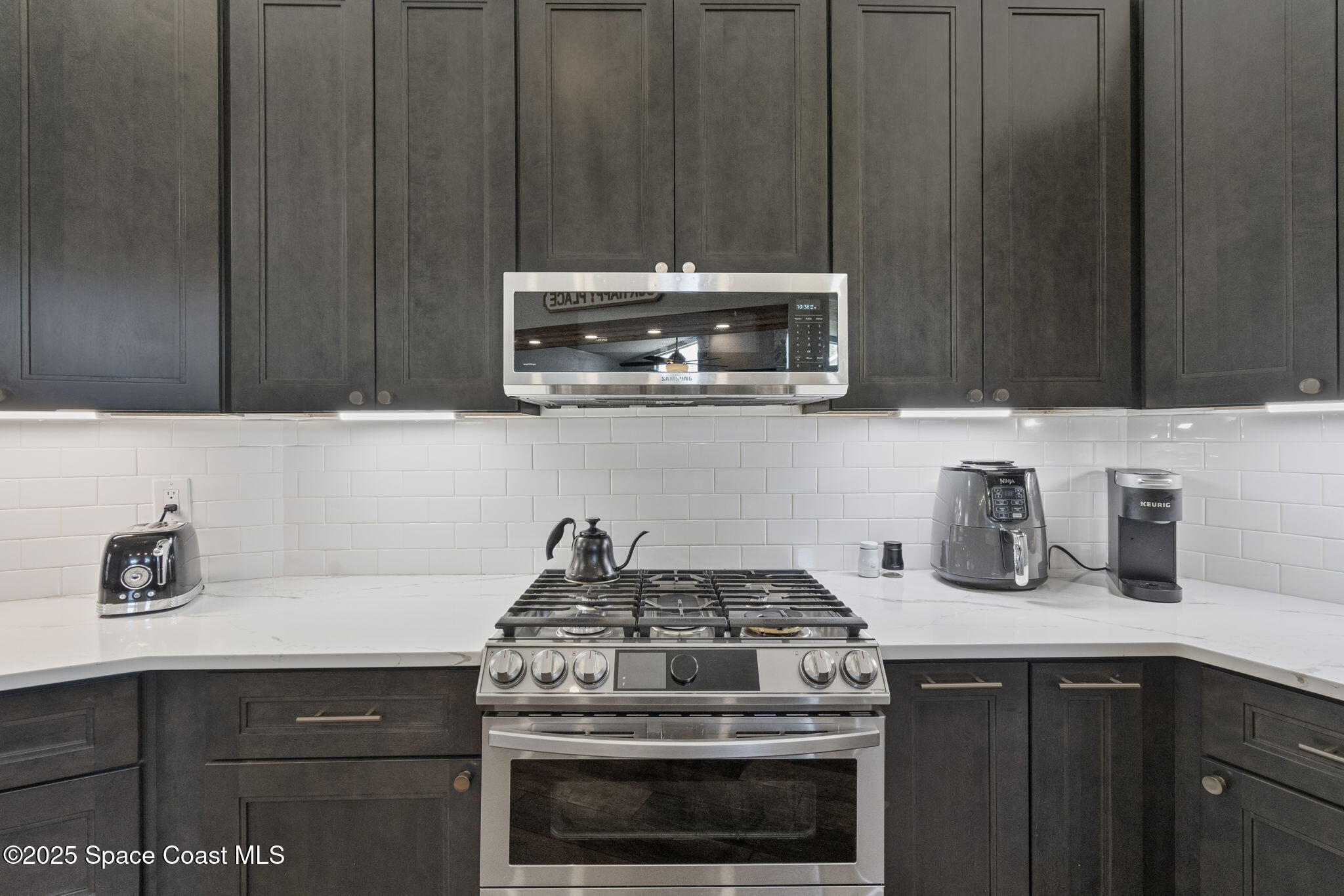 4089 Mallard Drive Melbourne, FL 32934 - Photo 21 of 53 a kitchen with granite countertop a stove a sink and cabinets