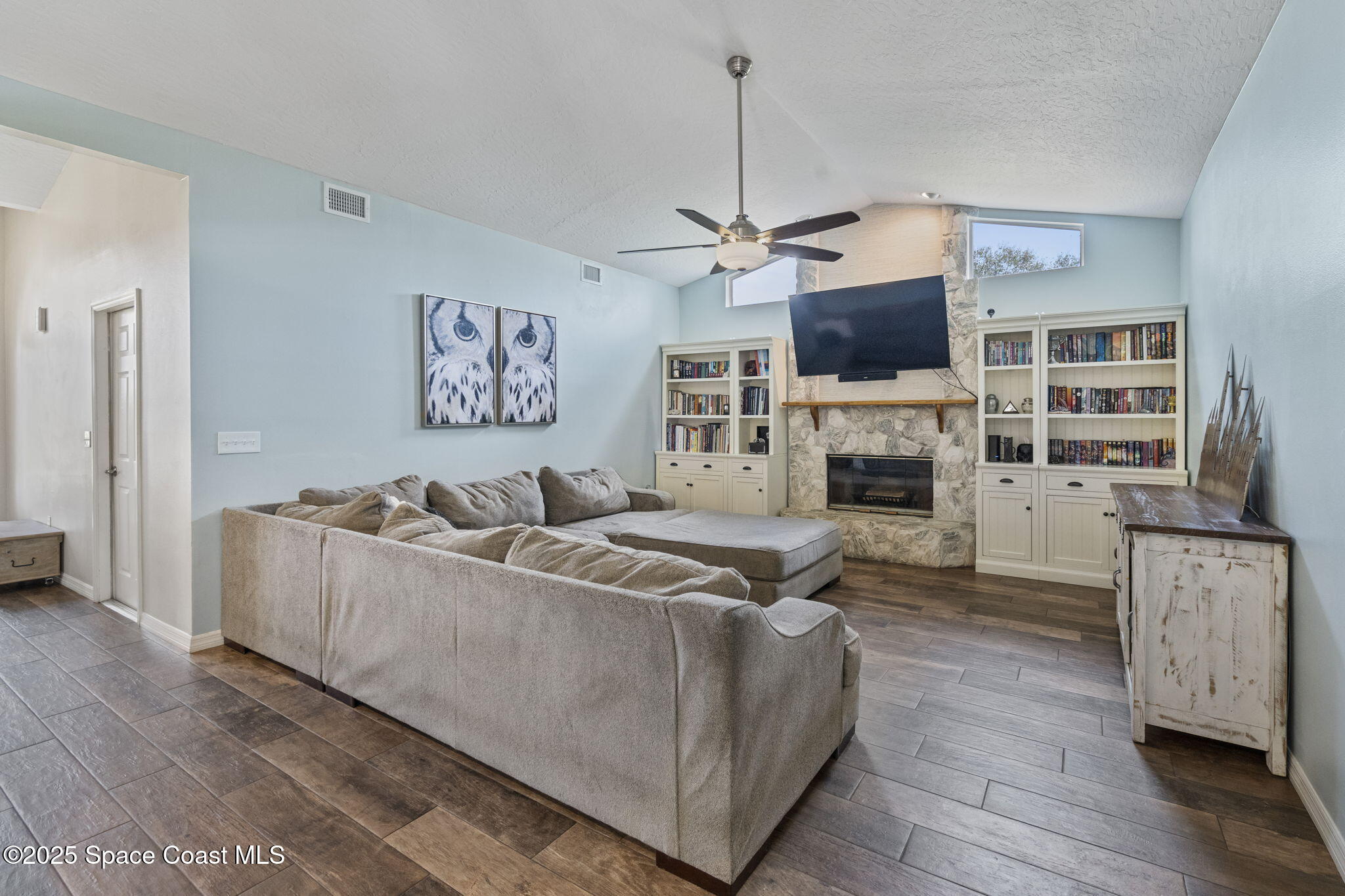 4089 Mallard Drive Melbourne, FL 32934 - Photo 23 of 53 a living room with furniture a fireplace and a flat screen tv