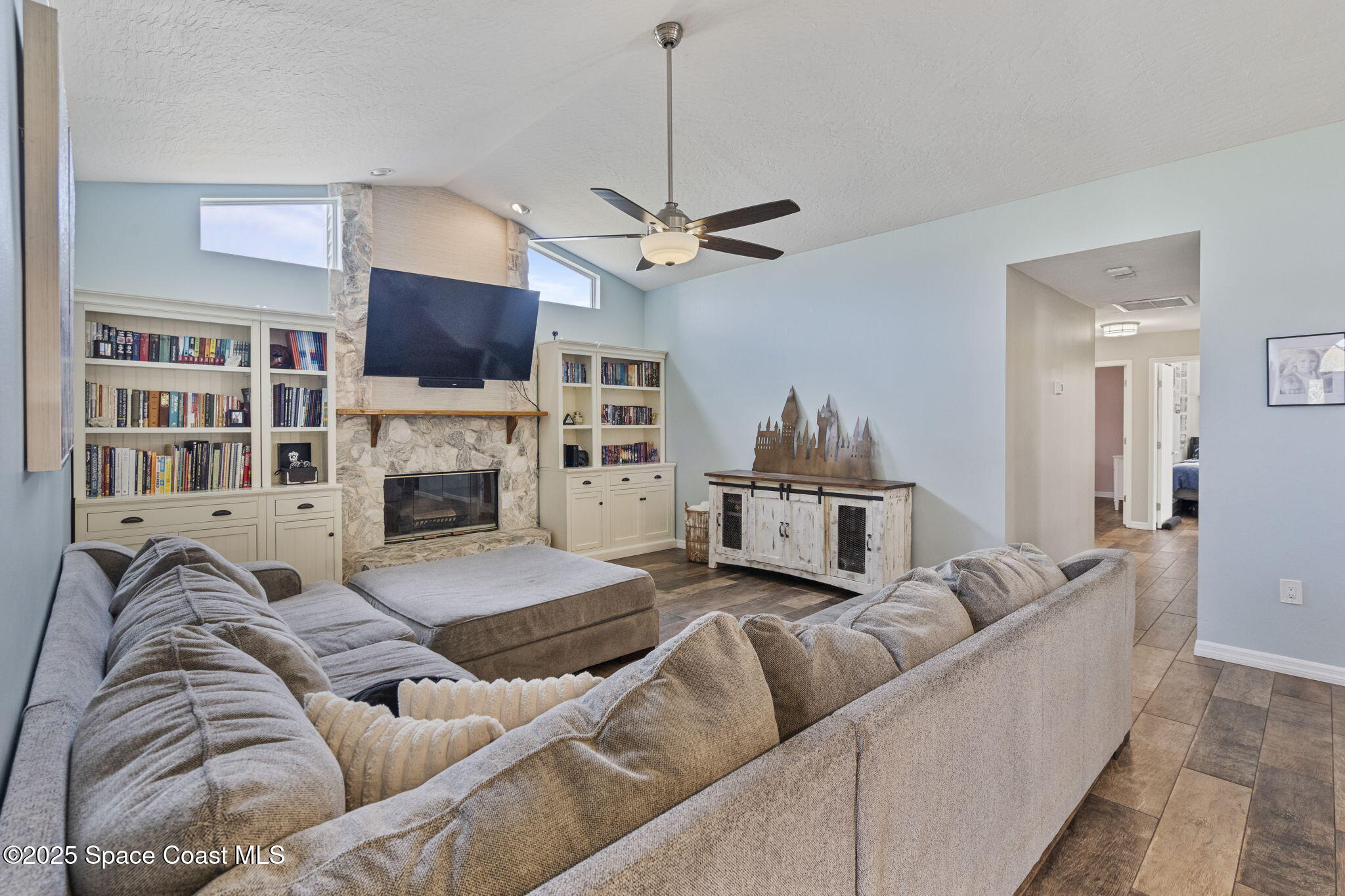 4089 Mallard Drive Melbourne, FL 32934 - Photo 24 of 53 a living room with furniture a fireplace and a chandelier