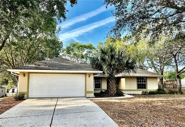 a view of a house with a patio and a yard