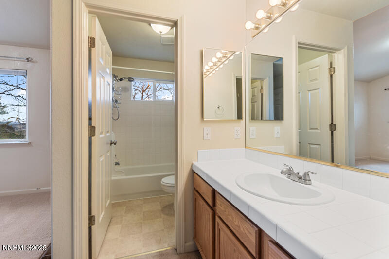 2990 Scottsdale Road Reno, NV 89512 - Photo 14 of 18 a bathroom with a granite countertop sink a mirror and a shower
