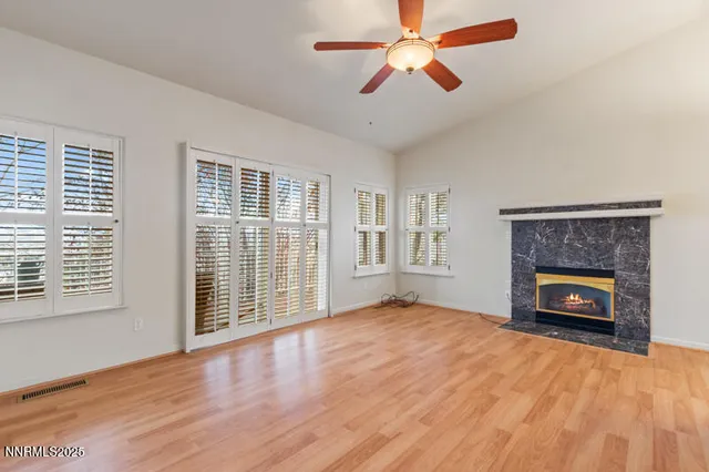 wooden floor fireplace and windows in an empty room