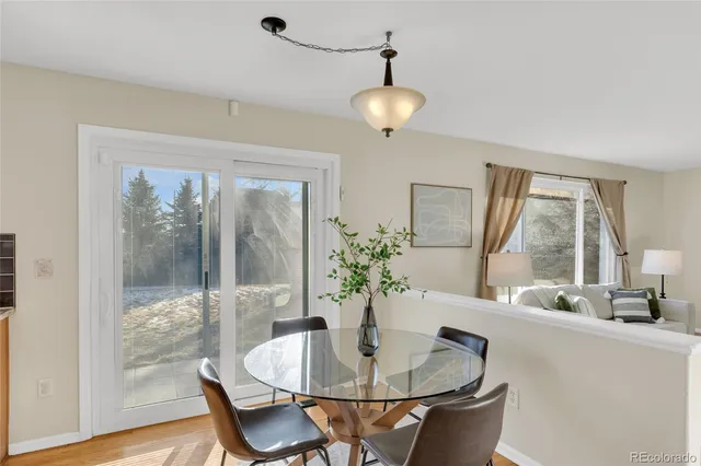 a dining room with furniture wooden floor a potted plant and a chandelier