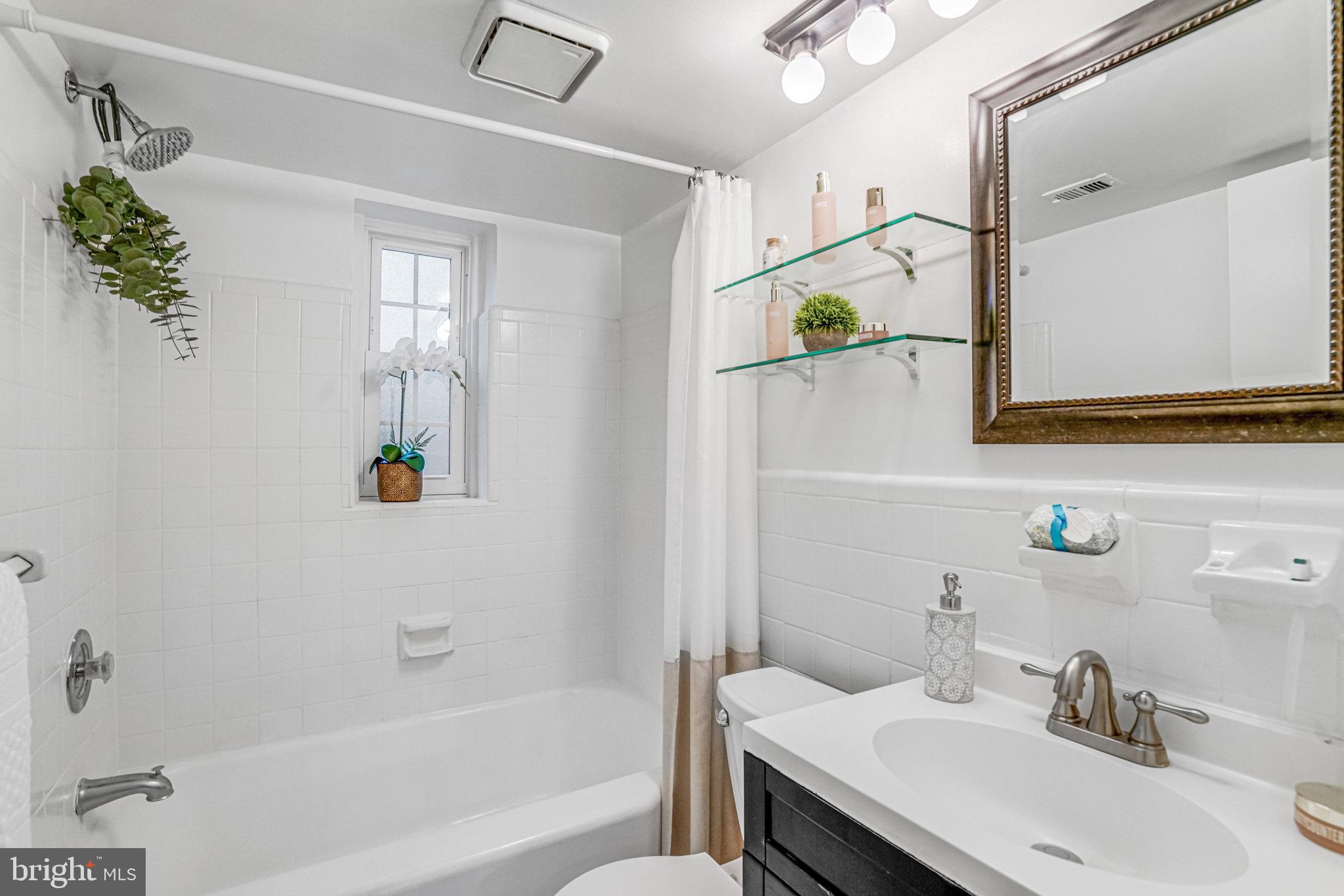 2106 North Scott Street, Unit 40 Arlington, VA 22209 - Photo 9 of 34 a bathroom with a sink mirror and a bathtub