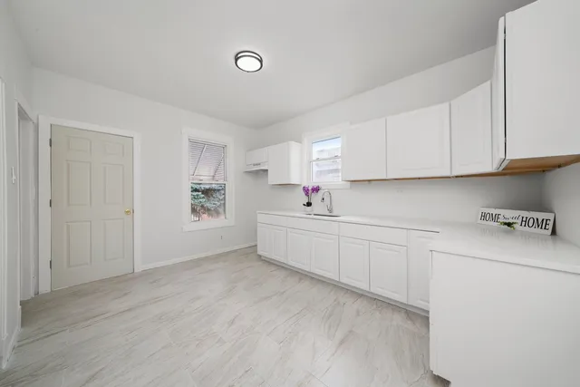 a kitchen with white cabinets and white appliances