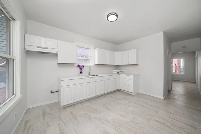 a kitchen with granite countertop white cabinets and white appliances