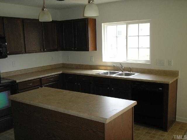 6004 Namozine Court Raleigh, NC 27610 - Photo 6 of 12 a kitchen with a sink a stove and cabinets