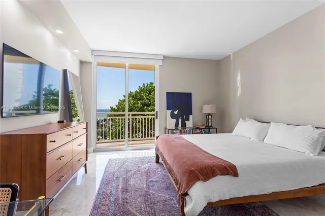 a bedroom with a balcony a bed and a flat screen tv