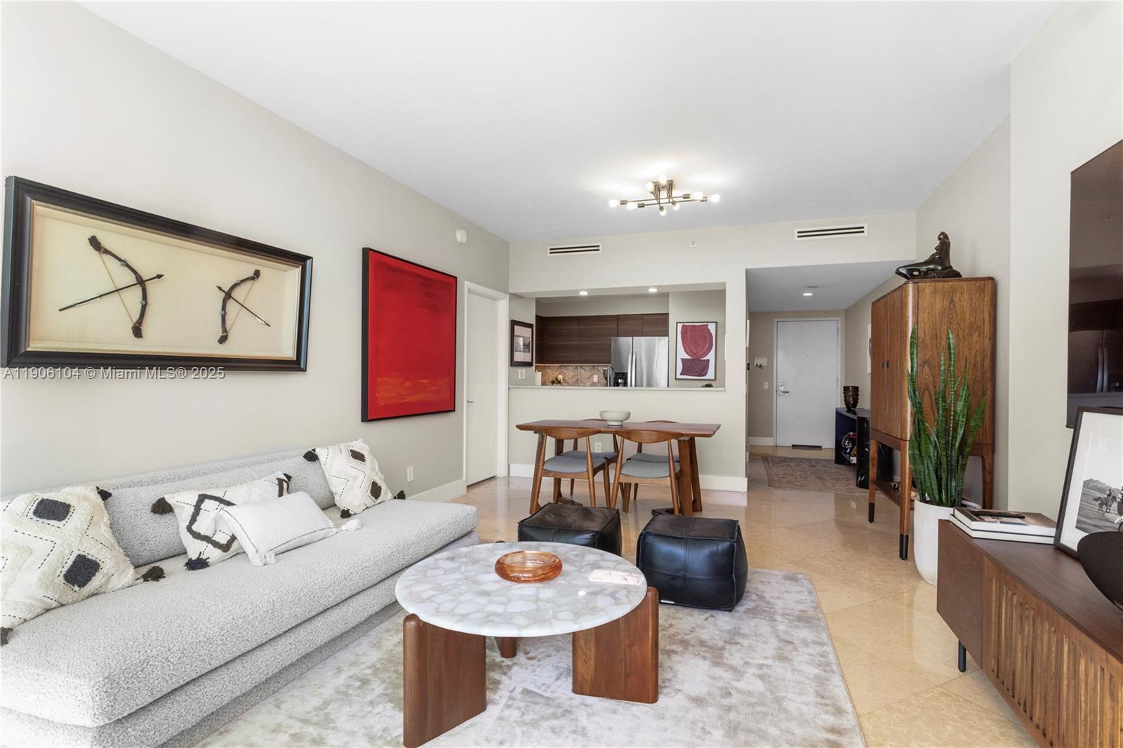 2475 Brickell Avenue, Unit 708 Miami, FL 33129 - Photo 2 of 21 a living room with furniture and a flat screen tv