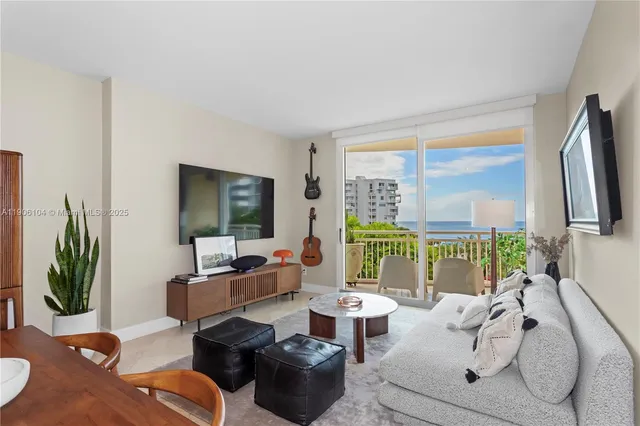 a living room with furniture large window and flat screen tv