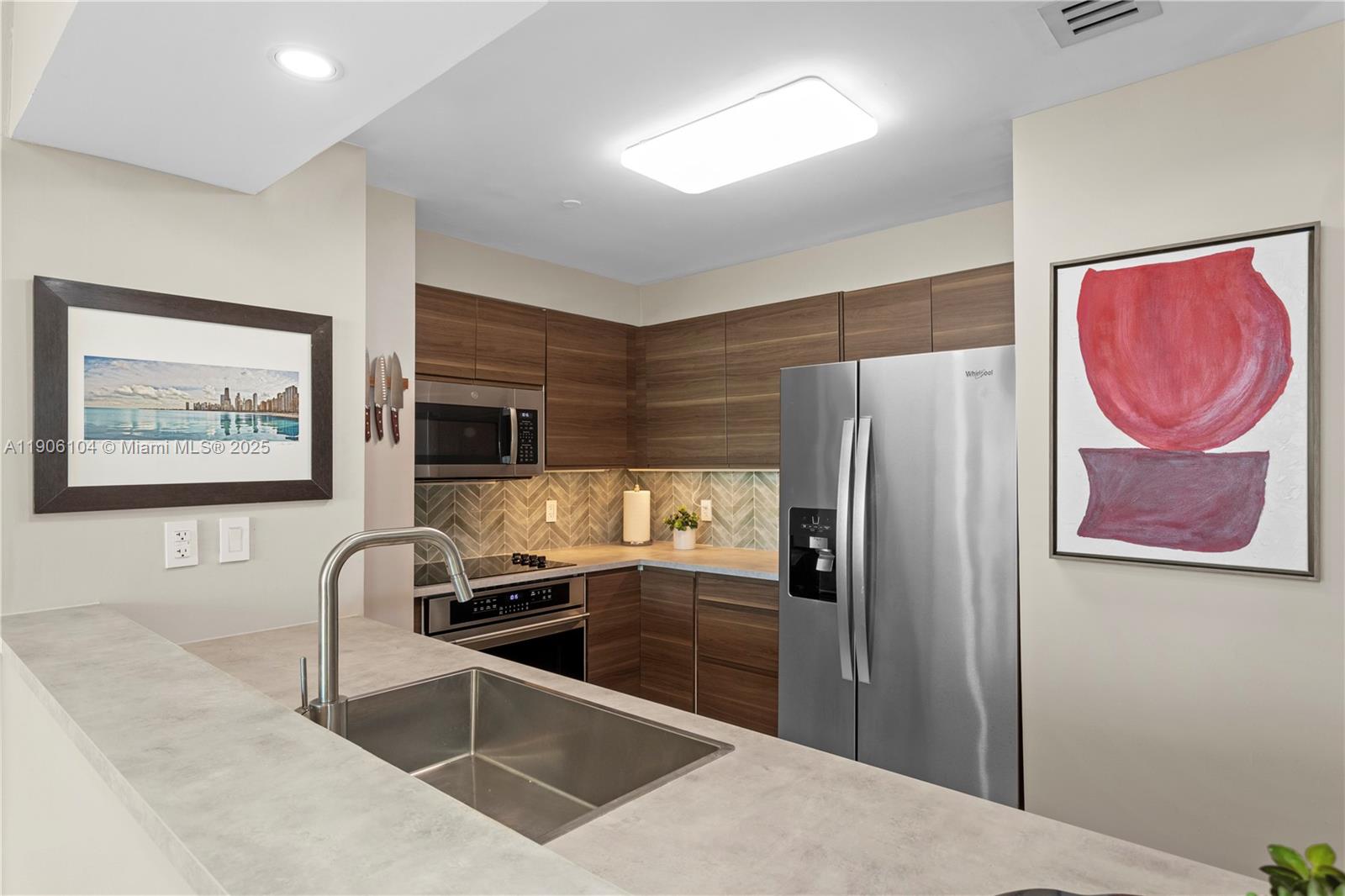 2475 Brickell Avenue, Unit 708 Miami, FL 33129 - Photo 10 of 21 a kitchen with granite countertop a refrigerator and a sink