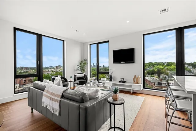a living room with furniture large windows and a flat screen tv