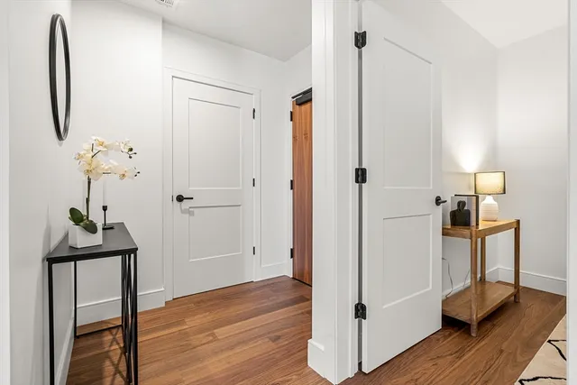 a view of a room with wooden floor and hallway